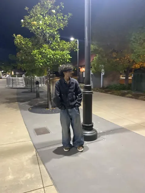 Samiel standing beneath a streetlamp at night